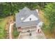 Aerial view of a two-story home surrounded by mature trees, featuring a full-length porch and beautifully landscaped yard at 83 Shipp Cir, Hiram, GA 30141