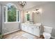 Bright bathroom featuring a double vanity, and large window with wooded view at 83 Shipp Cir, Hiram, GA 30141