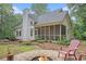 Beautiful home with a covered porch, fire pit area, mature landscaping, and a serene backyard setting at 83 Shipp Cir, Hiram, GA 30141