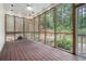 Inviting screened porch with stained wood flooring, roll-down shades, ceiling fan and lighting, overlooking a wooded backyard at 83 Shipp Cir, Hiram, GA 30141