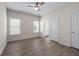 Bright bedroom with wood-look flooring, a ceiling fan, and access to the bathroom at 1666 Baxley Pine Trce, Suwanee, GA 30024