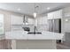 Bright kitchen featuring white cabinets, stainless steel appliances, and a large center island with countertop seating at 1666 Baxley Pine Trce, Suwanee, GA 30024