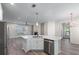 Open kitchen with stainless steel appliances, granite counters and a view of the living area with fireplace at 1666 Baxley Pine Trce, Suwanee, GA 30024