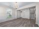 Spacious living area featuring hardwood floors, a chandelier, and natural light from large windows at 1666 Baxley Pine Trce, Suwanee, GA 30024
