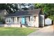 Gray single-story home with a dark roof, cute shutters, and a vibrant blue front door at 3046 Dobbs Way, East Point, GA 30344