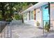 Close-up of the entrance with a charming stone patio, gray siding, cute shutters, and a blue front door at 3046 Dobbs Way, East Point, GA 30344