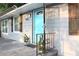 Close-up of the entrance with a charming stone patio, gray siding, cute shutters, and a blue front door at 3046 Dobbs Way, East Point, GA 30344