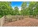Wooden back deck with built-in bench, overlooking a lush, green, wooded backyard at 345 Riverstone Dr, Hiram, GA 30141