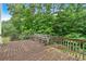 Wooden back deck with built-in bench, overlooking a lush, green, wooded backyard at 345 Riverstone Dr, Hiram, GA 30141