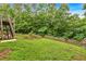 Spacious, grassy backyard with a tiered rock garden, bordered by a wood fence at 345 Riverstone Dr, Hiram, GA 30141