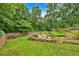 Lush backyard with landscaped garden area, wooden bridge, and wooded backdrop at 345 Riverstone Dr, Hiram, GA 30141