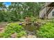 Backyard pond with stone waterfall and mature landscaping next to home at 345 Riverstone Dr, Hiram, GA 30141