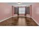 Bedroom with wood flooring, pink walls and a window with privacy blinds at 345 Riverstone Dr, Hiram, GA 30141