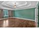 Bedroom showcasing tray ceiling, ample natural light, and wood floors at 345 Riverstone Dr, Hiram, GA 30141