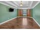 Bedroom showcasing tray ceiling, ample natural light, and wood floors at 345 Riverstone Dr, Hiram, GA 30141