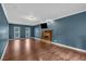 Cozy living room featuring a fireplace, hardwood floors and blue accent wall, perfect for relaxing at 345 Riverstone Dr, Hiram, GA 30141