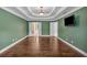 Main bedroom with tray ceiling, hardwood floors, TV and ensuite access at 345 Riverstone Dr, Hiram, GA 30141