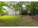 View of the backyard with a spacious deck, green lawn, and mature trees, offering a private outdoor space at 4435 Grove Nw Dr, Acworth, GA 30101