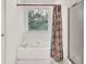 Bathroom featuring a tub, a window, and a glass-enclosed shower, offering a bright and comfortable space at 4435 Grove Nw Dr, Acworth, GA 30101