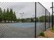 View of fenced community tennis court with well-maintained surface and lighting for evening play at 4435 Grove Nw Dr, Acworth, GA 30101