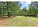 Expansive backyard with mature trees, green lawn, and a trampoline for outdoor fun and recreation at 217 Cedar Trl, Jonesboro, GA 30238