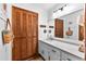 Well-lit bathroom featuring a shaker-style cabinet, neutral counters, and a vintage wood-paneled closet at 217 Cedar Trl, Jonesboro, GA 30238