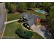 Aerial view of a brick home with a pool, lush lawn, and mature trees at 7804 Gusty Trl, Douglasville, GA 30135