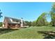 Expansive backyard with lush green grass, mature trees, and a charming deck perfect for outdoor entertaining at 7804 Gusty Trl, Douglasville, GA 30135