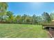 Expansive backyard featuring a well-maintained lawn, mature trees, and a wooden deck perfect for outdoor enjoyment at 7804 Gusty Trl, Douglasville, GA 30135