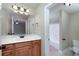 Bathroom boasts a wooden vanity with white countertops, large mirror, and shower/tub combo at 7804 Gusty Trl, Douglasville, GA 30135