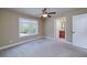 Bright bedroom features a ceiling fan, neutral walls, and large window providing abundant natural light at 7804 Gusty Trl, Douglasville, GA 30135