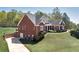Exterior view of a red brick home featuring mature landscaping, well-manicured lawn and driveway at 7804 Gusty Trl, Douglasville, GA 30135