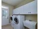 Convenient laundry room with washer, dryer, utility sink, and storage cabinets at 7804 Gusty Trl, Douglasville, GA 30135