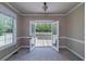 Bright living room featuring open doors to backyard deck, and a sunlit window at 7804 Gusty Trl, Douglasville, GA 30135