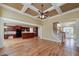 Open-concept living room with hardwood floors, coffered ceilings, and natural light, flowing into kitchen at 7804 Gusty Trl, Douglasville, GA 30135