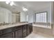 Bathroom featuring a bathtub, shower, double sinks, and granite countertops at 8360 Village School Dr, Cumming, GA 30041
