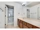 Well-lit bathroom featuring a marble-lined shower and a sleek vanity with ample counter space at 8360 Village School Dr, Cumming, GA 30041