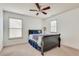 Cozy bedroom featuring neutral carpet, a ceiling fan, and abundant natural light from the windows at 8360 Village School Dr, Cumming, GA 30041