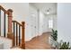 Spacious entry with hardwood floors, featuring a staircase and a view of the front door at 8360 Village School Dr, Cumming, GA 30041