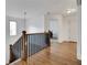 Hallway featuring hardwood floors and a wooden banister at 8360 Village School Dr, Cumming, GA 30041