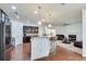 Open kitchen with stainless steel appliances and a breakfast bar overlooking the living room at 8360 Village School Dr, Cumming, GA 30041