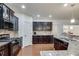 Well-equipped kitchen featuring dark wood cabinets, granite counters and modern appliances at 8360 Village School Dr, Cumming, GA 30041