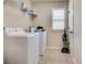 Functional laundry room with a washer, dryer, storage shelves, and natural light at 8360 Village School Dr, Cumming, GA 30041