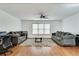 Bright living room with hardwood floors, gray couches, ceiling fan, and large window at 8360 Village School Dr, Cumming, GA 30041