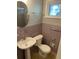 Cozy bathroom with window, pedestal sink and muted purple tile at 1177 Baker Ln, Marietta, GA 30062