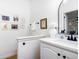 Bright half bathroom with a white vanity, stylish mirror, and decorative artwork at 3185 Perch Sw Dr, Marietta, GA 30008