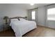 Bright bedroom with wood laminate flooring, a bed with two side tables, and two windows at 3185 Perch Sw Dr, Marietta, GA 30008