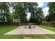 Sports court with outdoor seating, surrounded by green grass and a wooden fence at 3185 Perch Sw Dr, Marietta, GA 30008