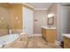 Bathroom featuring marble surround bathtub, stone floor tiles, and bright vanity at 3280 Stillhouse Se Ln # 108, Atlanta, GA 30339