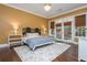 Sunlit bedroom with hardwood floors, large windows and door leading to an outdoor patio at 3280 Stillhouse Se Ln # 108, Atlanta, GA 30339